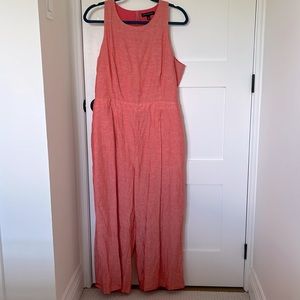 Coral colored, tank romper with pockets and wide leg cropped pants.